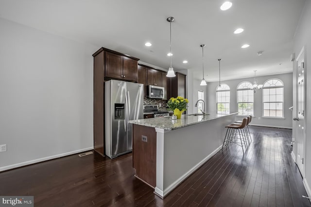 12517 Rustic Rock Ln, Beltsville, MD 20705 - kitchen with stainless steel appliances, a sink, dark brown cabinetry, a kitchen island with sink, and dark wood finished floors