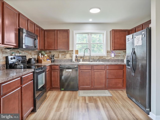 112 Toulouse Ln, Martinsburg, WV 25403 - kitchen featuring black appliances, a sink, tasteful backsplash, light wood-type flooring, and brown cabinetry