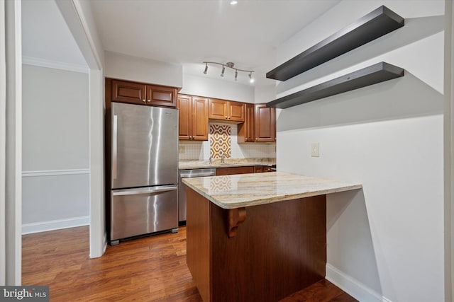 413 Eagle Rd # 7, Wayne, PA 19087 - kitchen featuring stainless steel appliances, tasteful backsplash, light stone countertops, wood finished floors, and a peninsula