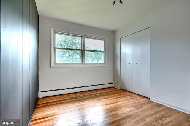 8429 Coco Rd, Baltimore, MD 21237 - unfurnished bedroom with a baseboard radiator, wood finished floors, and a closet