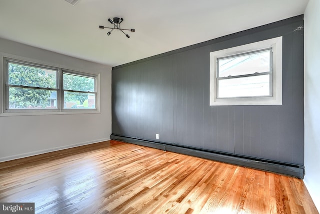 8429 Coco Rd, Baltimore, MD 21237 - spare room featuring wood finished floors, a baseboard heating unit, and baseboards