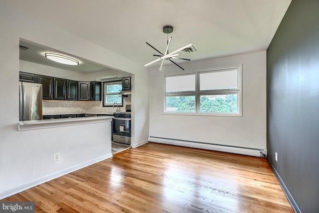 8429 Coco Rd, Baltimore, MD 21237 - kitchen with stainless steel appliances, baseboard heating, tasteful backsplash, and light wood-style floors