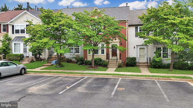 1085 Smartts Ln NE, Leesburg, VA 20176 - townhome / multi-family property with uncovered parking, brick siding, roof with shingles, and entry steps