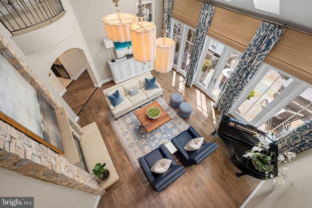 777 3rd St, Herndon, VA 20170 - living area with hardwood / wood-style flooring, baseboards, a towering ceiling, and arched walkways