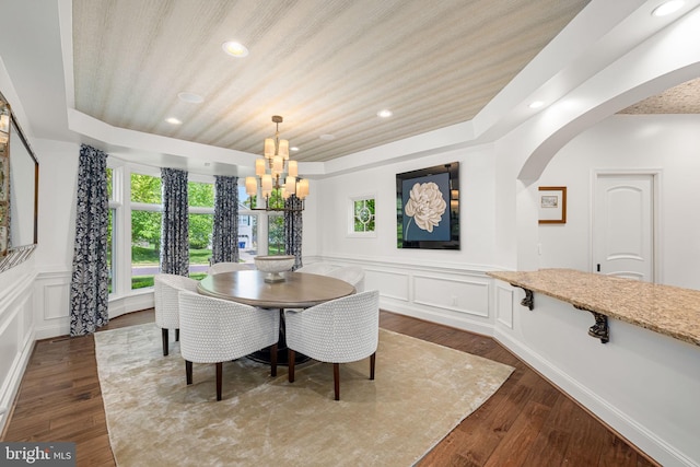777 3rd St, Herndon, VA 20170 - dining space with a chandelier, a decorative wall, wainscoting, arched walkways, and dark wood-type flooring