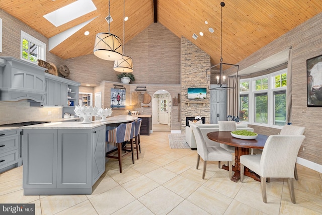 777 3rd St, Herndon, VA 20170 - dining area with high vaulted ceiling, a stone fireplace, wood ceiling, a skylight, and healthy amount of natural light