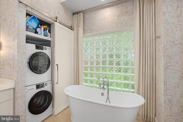 777 3rd St, Herndon, VA 20170 - full bath with stacked washing machine and dryer, a freestanding tub, and tile patterned floors