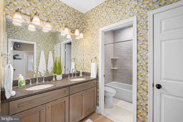 777 3rd St, Herndon, VA 20170 - bathroom featuring double vanity, toilet, shower / bathtub combination, and wood finished floors