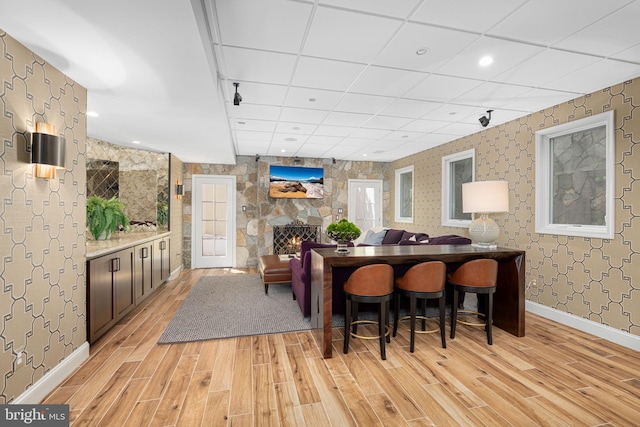 777 3rd St, Herndon, VA 20170 - dining room with light wood-type flooring, wallpapered walls, a stone fireplace, recessed lighting, and baseboards