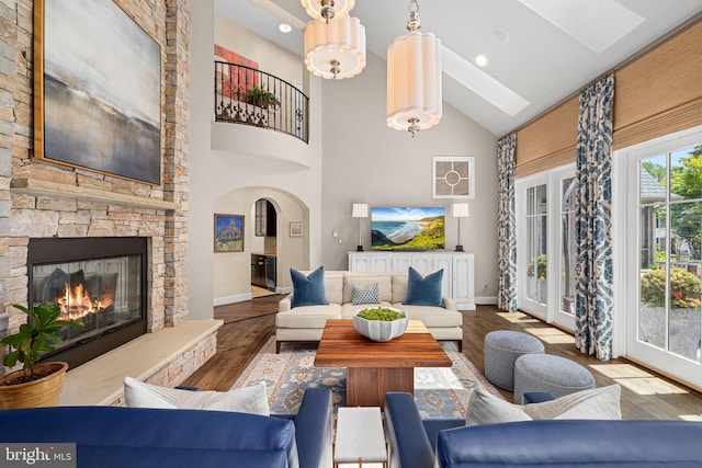 777 3rd St, Herndon, VA 20170 - living room with high vaulted ceiling, wood finished floors, baseboards, a skylight, and a stone fireplace
