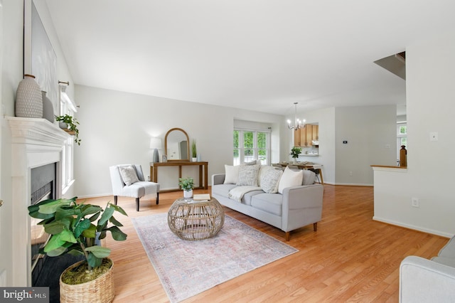 6201 Knolls Ct, Elkridge, MD 21075 - living room with a chandelier, light wood-style floors, a fireplace, and baseboards