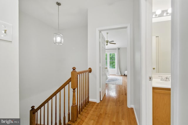 6201 Knolls Ct, Elkridge, MD 21075 - hallway with light wood finished floors, an upstairs landing, a sink, and baseboards