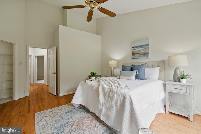 6201 Knolls Ct, Elkridge, MD 21075 - bedroom with wood finished floors, a high ceiling, baseboards, a ceiling fan, and a walk in closet