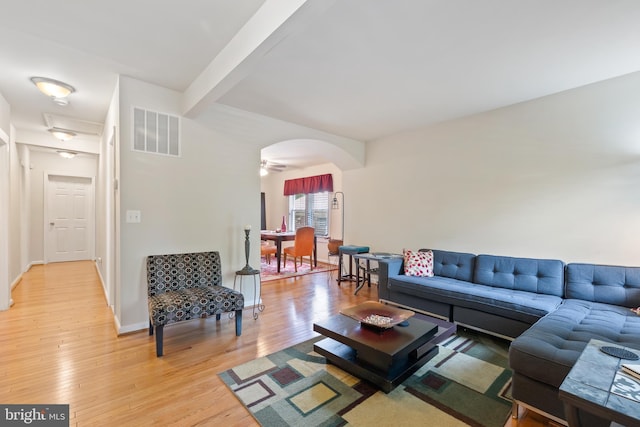 4909 Meade St NE, Washington, DC 20019 - living area with arched walkways, light wood-style flooring, beamed ceiling, and baseboards