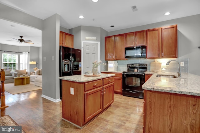 3061 Raking Leaf Dr, Abingdon, MD 21009 - kitchen featuring black appliances, a sink, light wood-type flooring, light stone counters, and recessed lighting