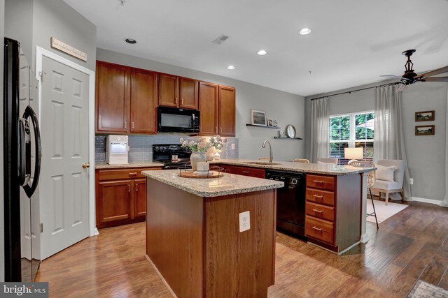 3061 Raking Leaf Dr, Abingdon, MD 21009 - kitchen featuring black appliances, a peninsula, a sink, a center island, and light wood finished floors