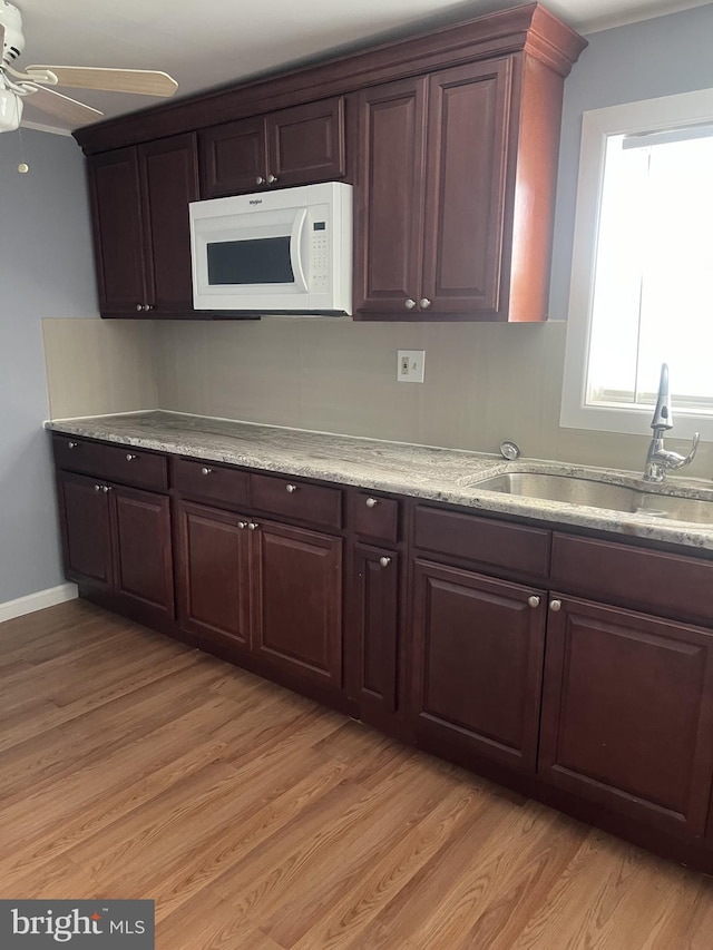 4839 Griscom St, Philadelphia, PA 19124 - kitchen with white microwave, a ceiling fan, a sink, and light wood-type flooring