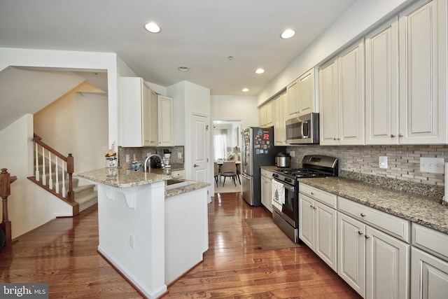 714 Shady Creek Ct, Bel Air, MD 21015 - kitchen with stainless steel appliances, wood finished floors, decorative backsplash, a sink, and a breakfast bar area