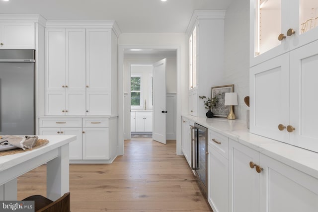 3718 Gradyville Rd, Newtown Square, PA 19073 - kitchen featuring stainless steel refrigerator, white cabinetry, light wood-style floors, beverage cooler, and light stone countertops