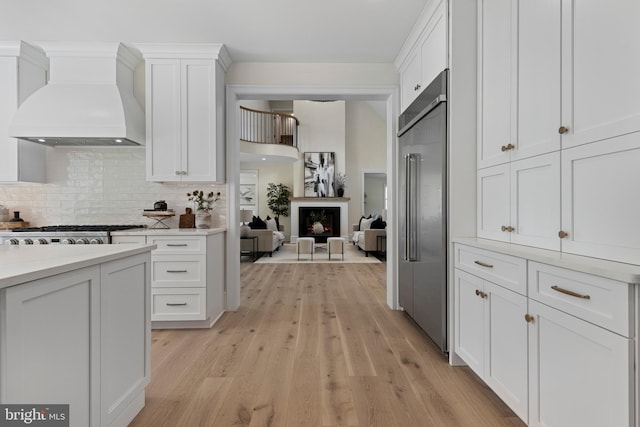 3718 Gradyville Rd, Newtown Square, PA 19073 - kitchen with custom range hood, appliances with stainless steel finishes, white cabinets, and light countertops