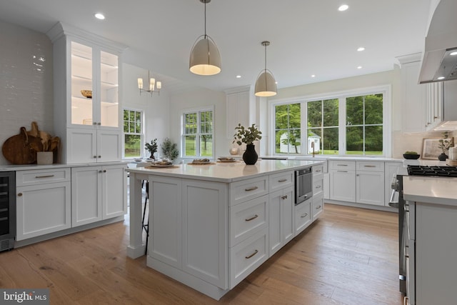 3718 Gradyville Rd, Newtown Square, PA 19073 - kitchen with white cabinetry, wall chimney exhaust hood, light countertops, a kitchen island, and recessed lighting