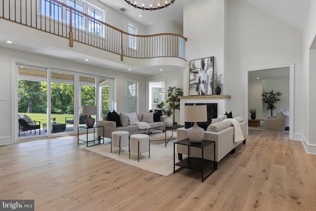 3718 Gradyville Rd, Newtown Square, PA 19073 - living area with a towering ceiling, wood finished floors, a chandelier, a glass covered fireplace, and recessed lighting