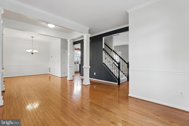 9901 Airedale Ct, Bristow, VA 20136 - spare room featuring decorative columns, light wood-style flooring, ornamental molding, baseboards, and stairway
