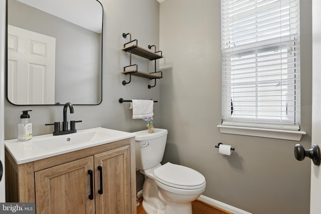 9901 Airedale Ct, Bristow, VA 20136 - half bathroom featuring toilet, vanity, baseboards, and wood finished floors