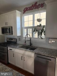 9901 Airedale Ct, Bristow, VA 20136 - kitchen with appliances with stainless steel finishes, a sink, white cabinets, and light stone countertops