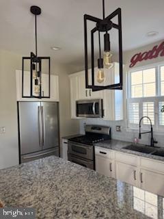 9901 Airedale Ct, Bristow, VA 20136 - kitchen featuring stainless steel appliances, a sink, white cabinets, and light stone countertops