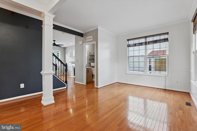 9901 Airedale Ct, Bristow, VA 20136 - empty room with ornate columns, light wood finished floors, stairs, baseboards, and a ceiling fan