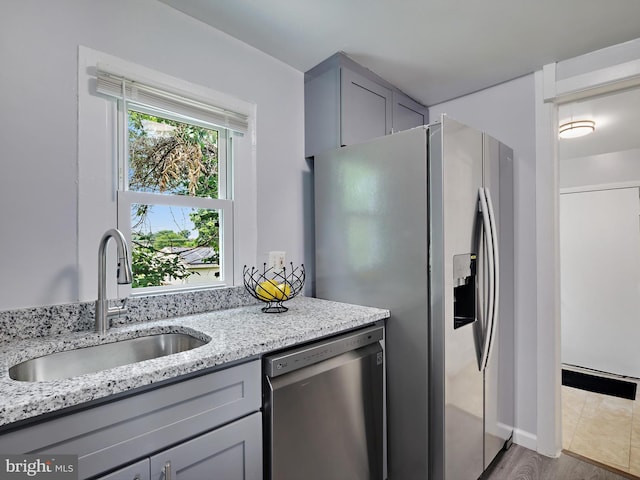 6202 K St, Capitol Heights, MD 20743 - kitchen with appliances with stainless steel finishes, a sink, gray cabinetry, light stone counters, and baseboards