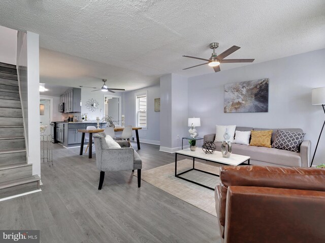 6202 K St, Capitol Heights, MD 20743 - living room with a ceiling fan, stairs, light wood finished floors, and a textured ceiling