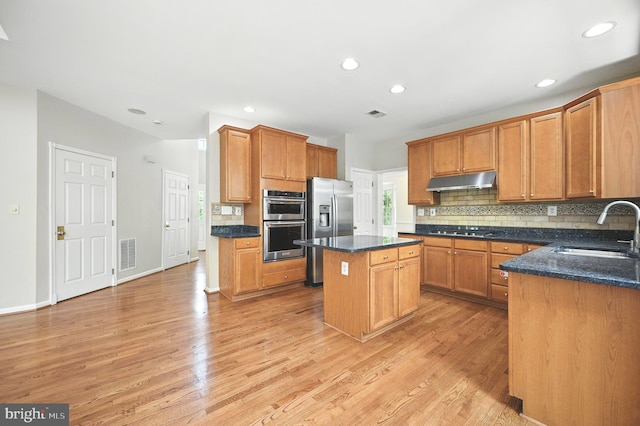 10861 Hunter Gate Way, Reston, VA 20194 - kitchen featuring appliances with stainless steel finishes, under cabinet range hood, decorative backsplash, light wood-style floors, and recessed lighting