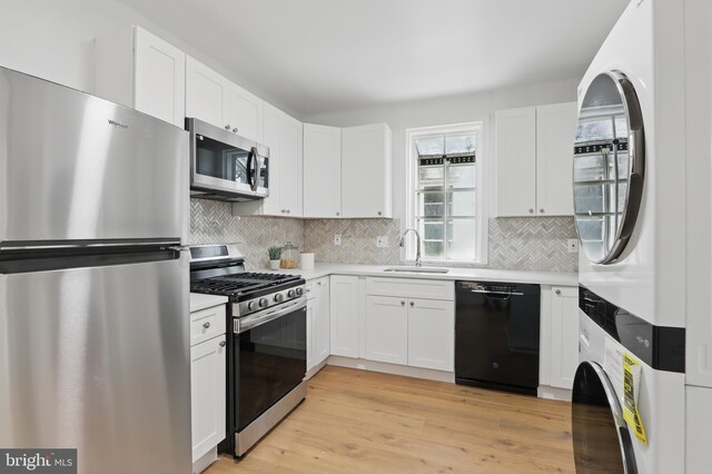 405 Calvin Ave, Baltimore, MD 21218 - kitchen with stainless steel appliances, a sink, light countertops, white cabinets, and backsplash