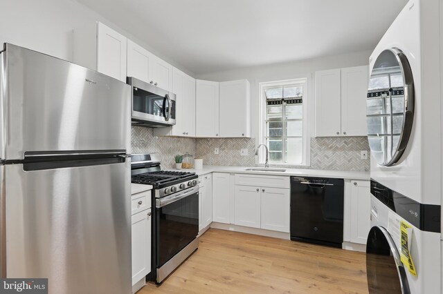 405 Calvin Ave, Baltimore, MD 21218 - kitchen featuring appliances with stainless steel finishes, a sink, stacked washer / dryer, light countertops, and backsplash
