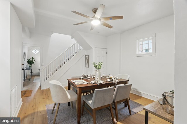 405 Calvin Ave, Baltimore, MD 21218 - dining space featuring stairway, light wood-style flooring, a ceiling fan, and baseboards