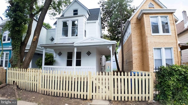405 Calvin Ave, Baltimore, MD 21218 - view of front of home with a porch, a fenced front yard, and a shingled roof