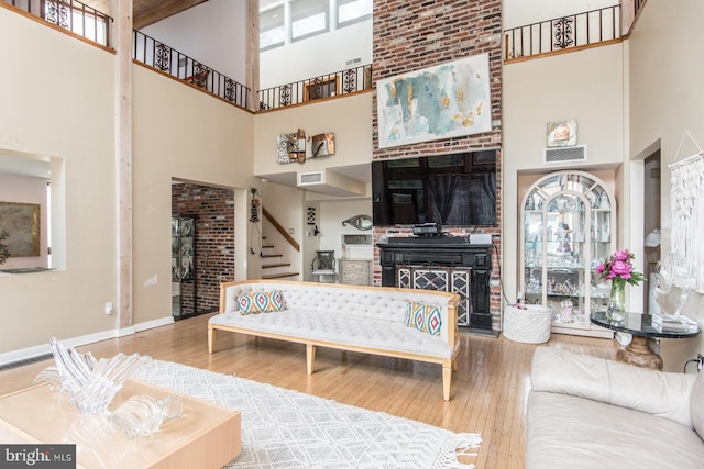2500 Edge Hill Rd, Huntingdon Valley, PA 19006 - living room featuring a high ceiling, stairs, wood finished floors, a fireplace, and baseboards