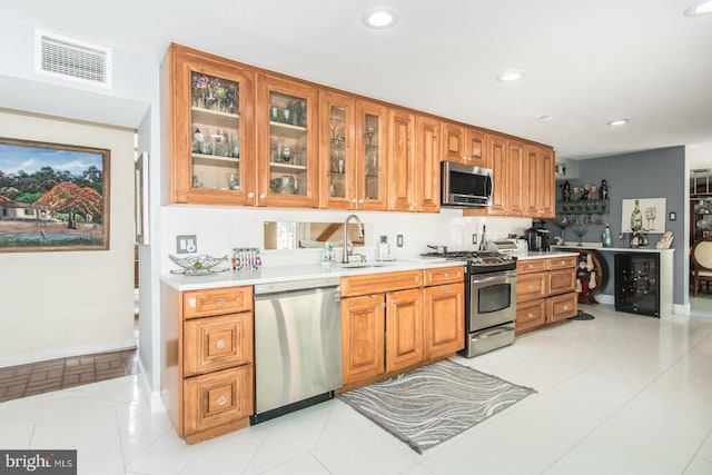 2500 Edge Hill Rd, Huntingdon Valley, PA 19006 - kitchen with appliances with stainless steel finishes, a sink, light countertops, glass insert cabinets, and recessed lighting