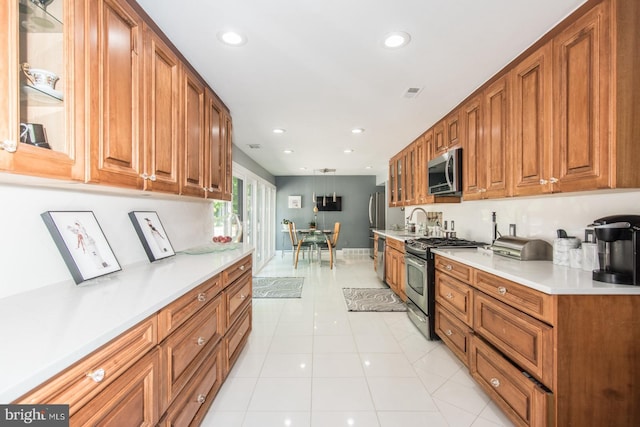 2500 Edge Hill Rd, Huntingdon Valley, PA 19006 - kitchen with stainless steel appliances, brown cabinetry, light countertops, a sink, and recessed lighting