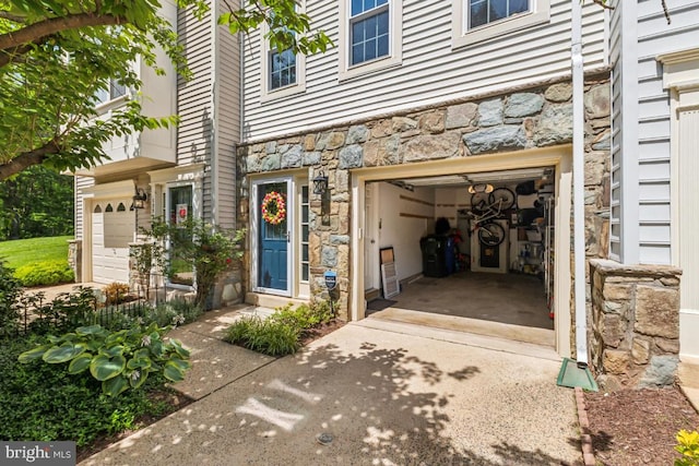 13512 Turquoise Ln, Herndon, VA 20170 - view of exterior entry with stone siding, concrete driveway, and an attached garage