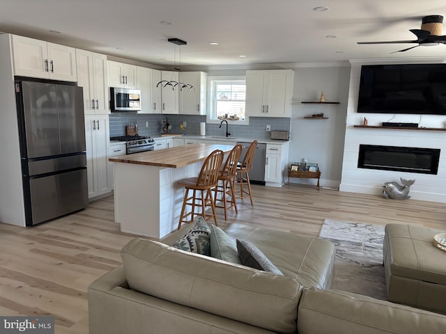4112 Park Blvd Unit G, Wildwood, NJ 08260 - kitchen with open floor plan, appliances with stainless steel finishes, wood counters, ceiling fan, and ornamental molding