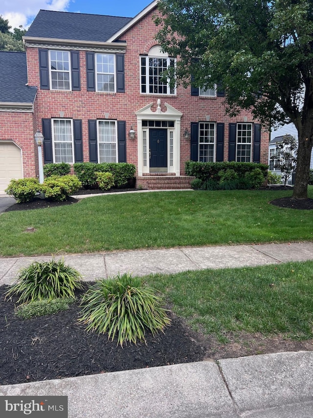 8242 Green Ice Dr, Pasadena, MD 21122 - colonial house with brick siding, a front yard, and a shingled roof