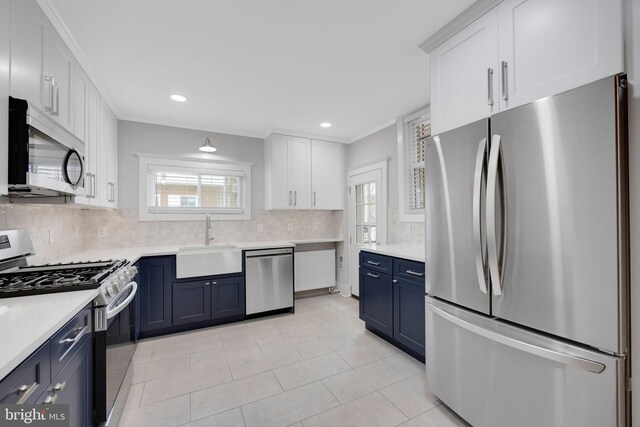 4441 Sherwood Rd, Philadelphia, PA 19131 - kitchen featuring stainless steel appliances, a sink, blue cabinets, decorative backsplash, and white cabinetry