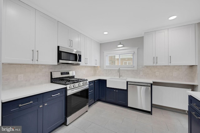 4441 Sherwood Rd, Philadelphia, PA 19131 - kitchen featuring stainless steel appliances, a sink, blue cabinets, white cabinetry, and ornamental molding