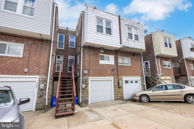 4441 Sherwood Rd, Philadelphia, PA 19131 - view of front of property with driveway, an attached garage, stone siding, brick siding, and stairs