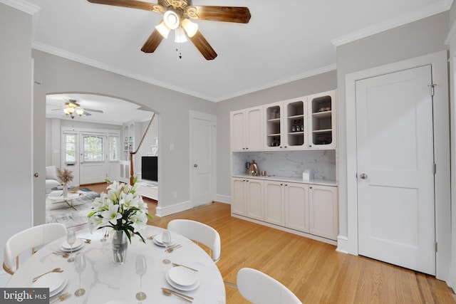 4441 Sherwood Rd, Philadelphia, PA 19131 - dining space featuring ceiling fan, arched walkways, light wood-type flooring, crown molding, and baseboards