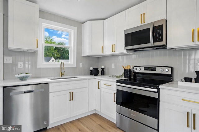 12 N Hawthorne Rd N, Middle River, MD 21220 - kitchen featuring appliances with stainless steel finishes, a sink, white cabinets, and tasteful backsplash