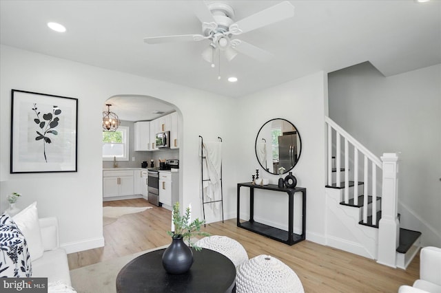 12 N Hawthorne Rd N, Middle River, MD 21220 - living area with stairway, light wood-style flooring, ceiling fan, arched walkways, and baseboards